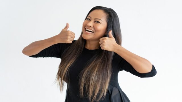 Cheerful middle-aged woman showing thumbs up