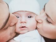 Attachment vs Detachment Dad and mom kissing their child