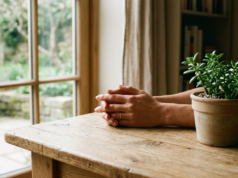 PCOS: Signs, Causes, Treatment and Fertility Hands resting calmly on a light wooden table beside a small green plant