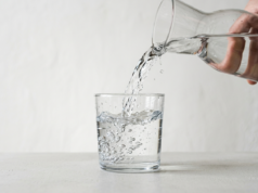 How Much Water Should You Drink a Day? A clear glass of water mid-pour with crisp refraction and rising bubbles
