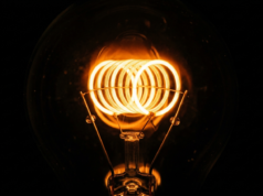 How Does Electricity Work? From Electrons to Your Socket Macro photograph of a glowing incandescent filament coil burning bright against darkness