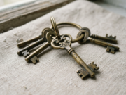 Password Managers Explained: How They Keep You Safe A small ring of brass keys on a pale surface with one key in sharp focus