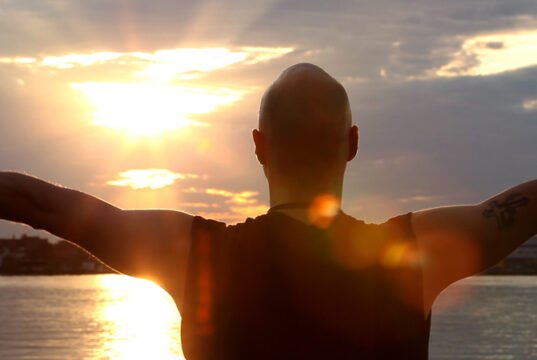 Chakras Explained: Origins, the Seven Centres and What Evidence Says Silhouette of a person sun gazing against a bright sky
