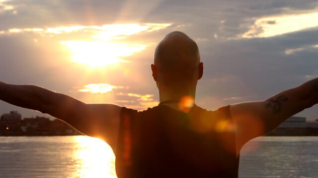 Silhouette of a person sun gazing against a bright sky