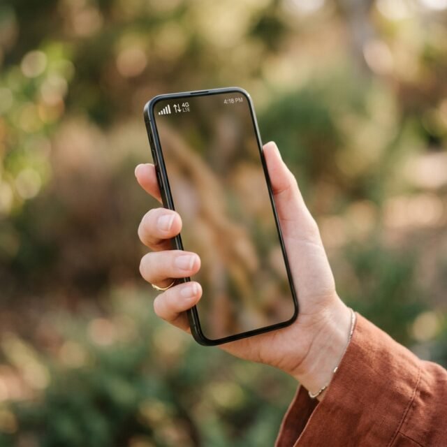 mobile-data-not-working-fixes hero Smartphone showing signal bars and a data icon held in a hand