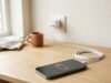 Phone Battery Draining Fast? 8 Fixes That Actually Work Smartphone showing a low battery icon on a desk