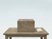 Spain Snap Election: Housing at the Centre of Sánchez’s Gamble AI-generated illustration of a wooden ballot box and a stack of paper ballots on a table in an empty town square